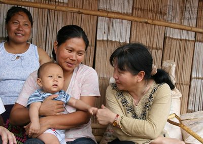 Tawny Thanh visiting with a mother and child, Thailand, 2005
