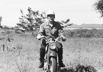 Fr. John P. Casey riding a motorcycle in Tanzania