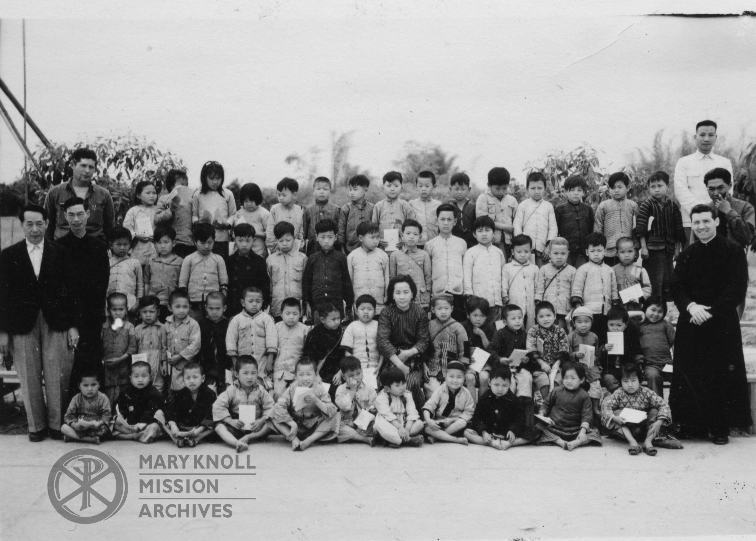 Fr. John F. Donovan with children of the Refugee Children's School, Kaying, 1945