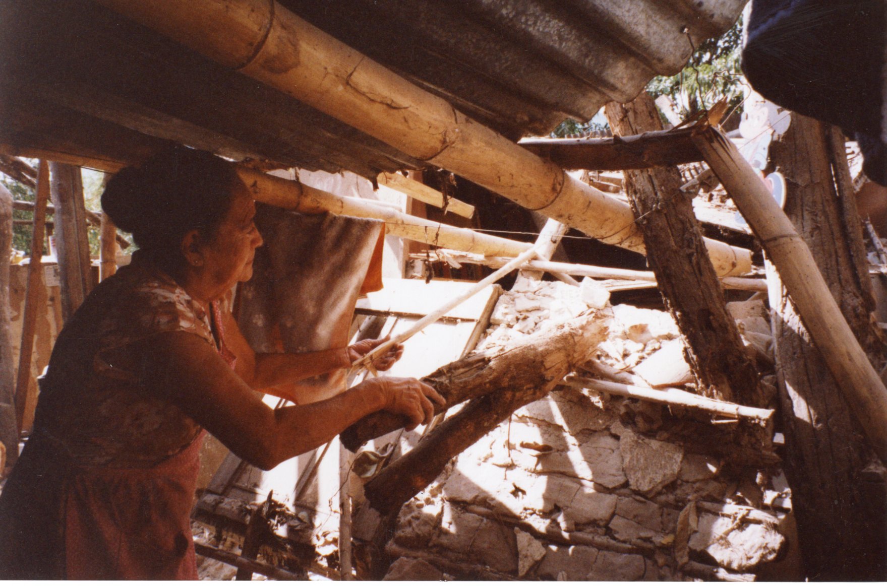 Salvadoran woman Salvadoran woman going through the debris of her home, 2001