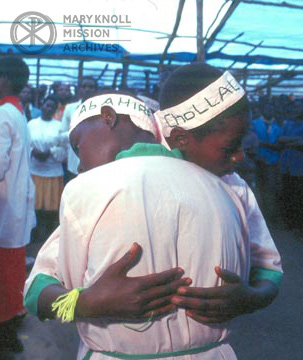 Two people hug one another during a "dance of peace" performed during Holy Thursday liturgy at Kitali refugee camp in Tanzania, 1996