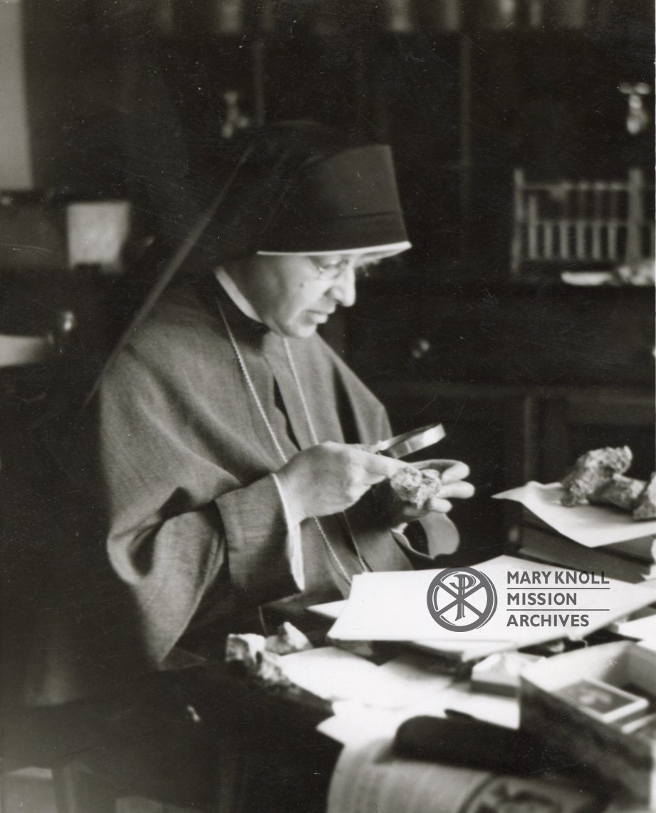 Sister Mary Corder Lorang studying rocks with a magnifying glass