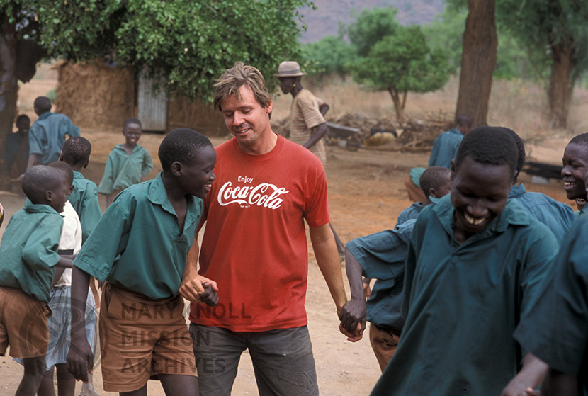Former Maryknoll Lay Missioner, Marty Roers dancing with parish school boys in Sudan, 2002