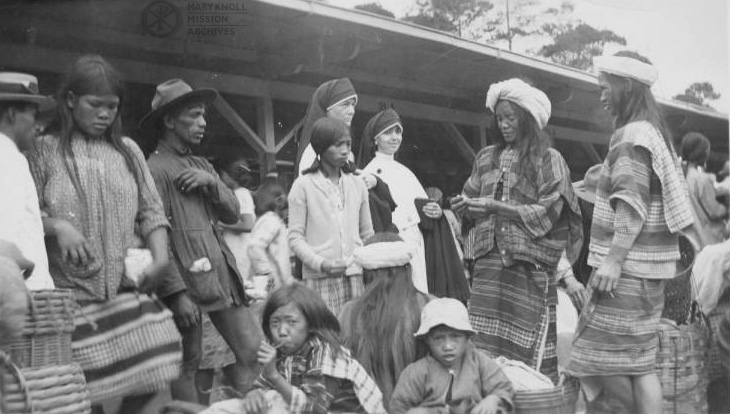 Maryknoll Sisters Lucy Leduc and Celeste Riemen standing among indigenous<br />
people in a market,<br />
Baguio, Philippines, March 24, 1935